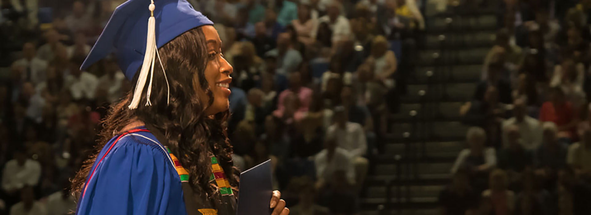 Graduate crosses the stage at Commencement