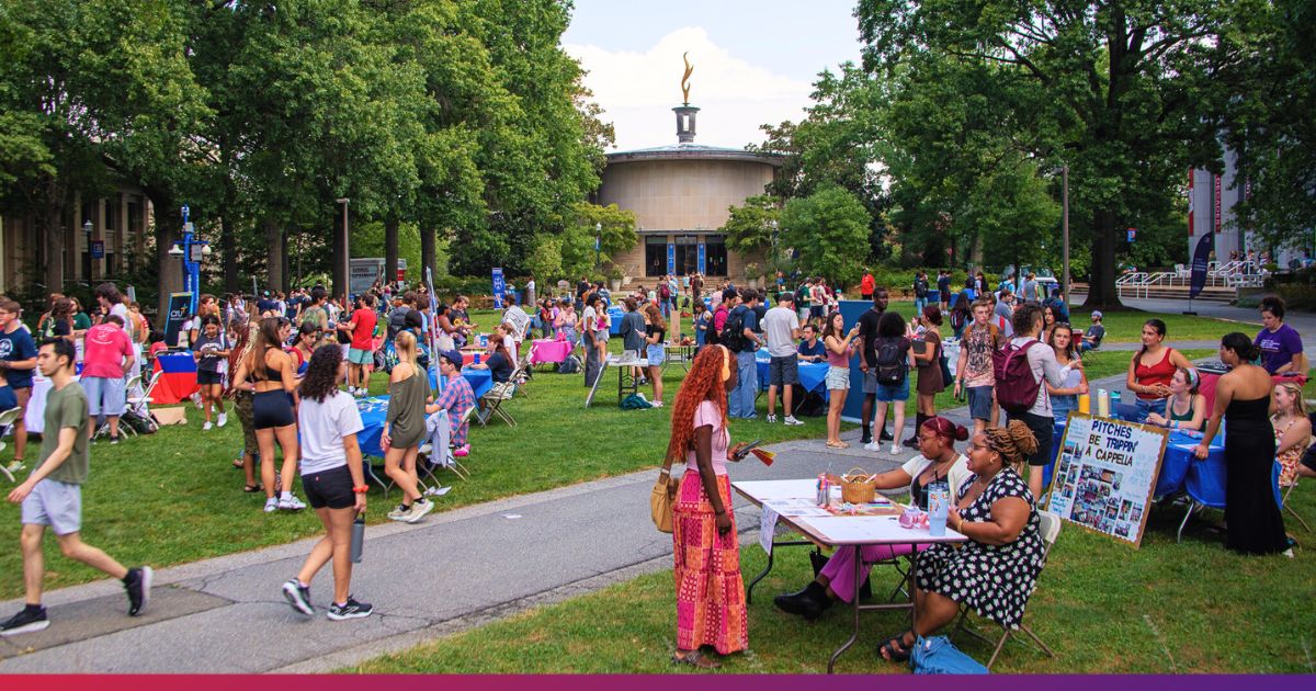 Large Group of American University Students Gathering on the Quad for a Student Involvement Fair. Kay Spiritual Life Center is seen in the background.
