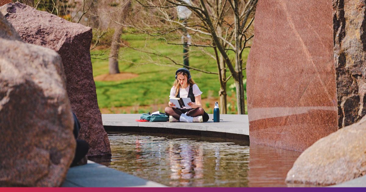 Student Studying Solo by the Sudama Boulders at American University