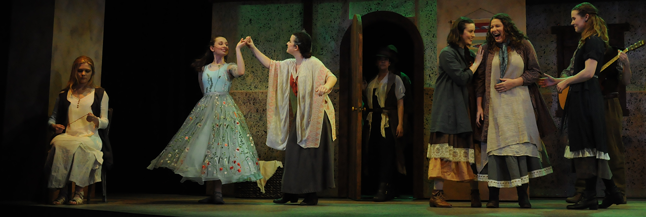 People in long skirts dance onstage