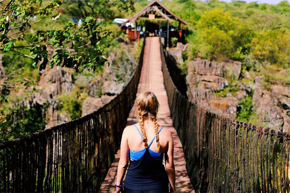 Student on footbridge across a gorge. Student on footbridge across a gorge.