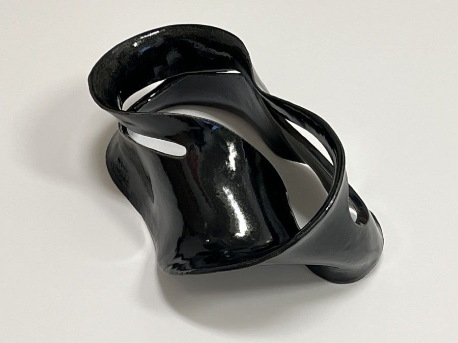 Julia Cheng Zhang, Möbius Strip Variation I. A glossy black ceramic mobius strip. 