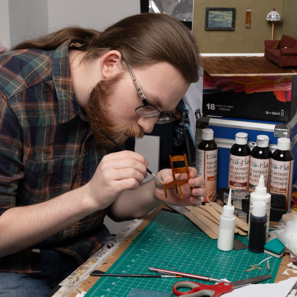 Connor Gagne painting miniature chair