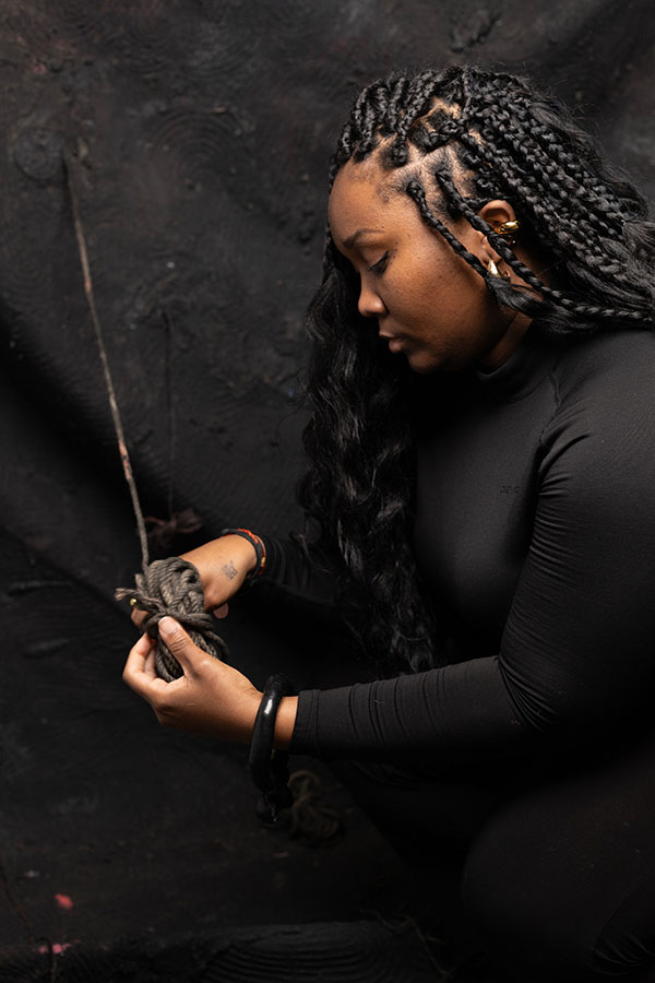 Patricia E Poku holding a bundle of rope or twine