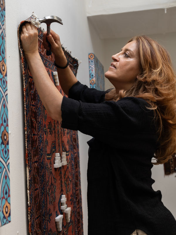Phaedra Askarinam nailing textile to wall
