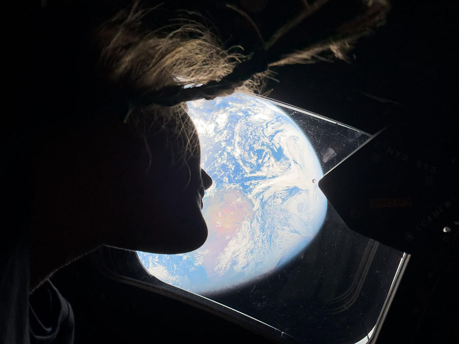 NASA astronaut Christina Koch peers out of one of the Orion spacecraft's cabin windows, looking back at Earth, as the crew travels towards the Moon. Photo courtesy of NASA.