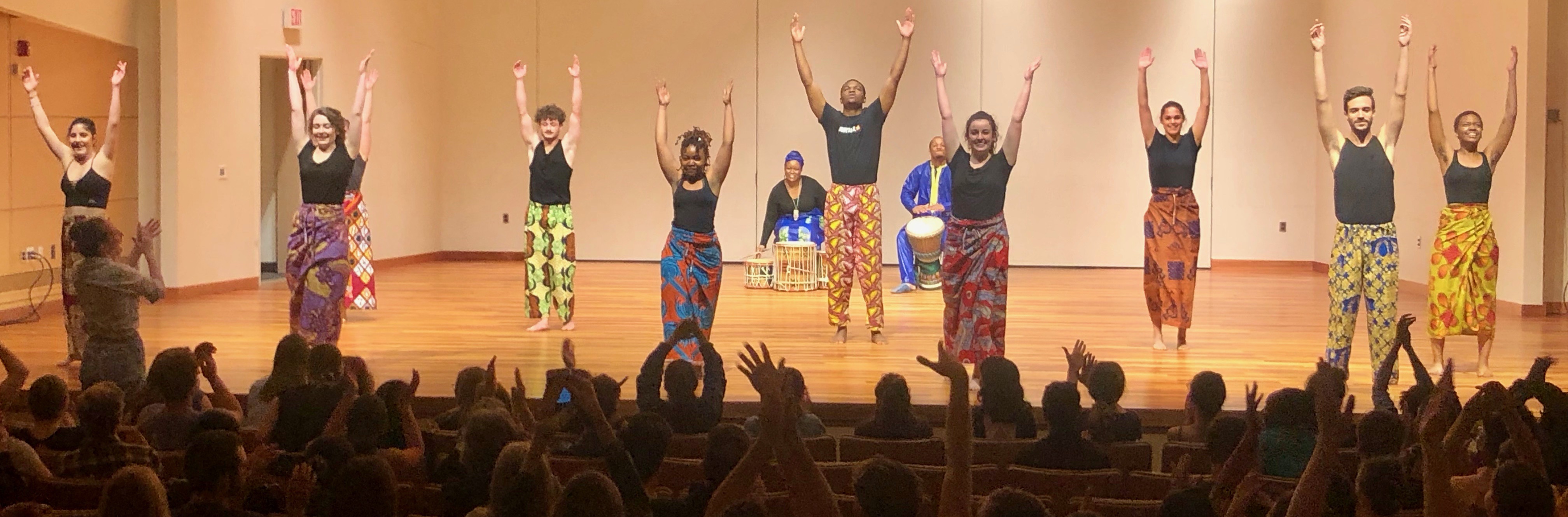 Dances strike their final pose while the audience cheers at AU Dances