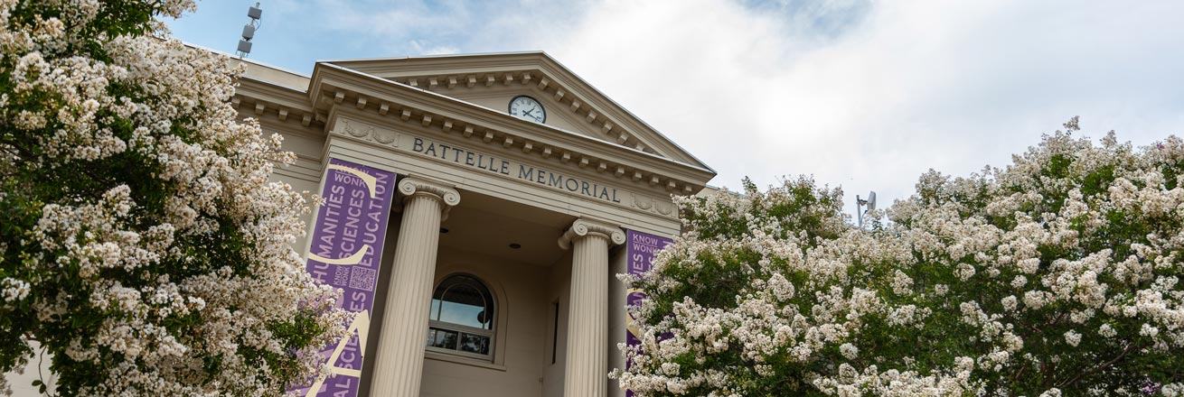 Battelle-Tompkins Memorial Building surrounded by blooming foliage