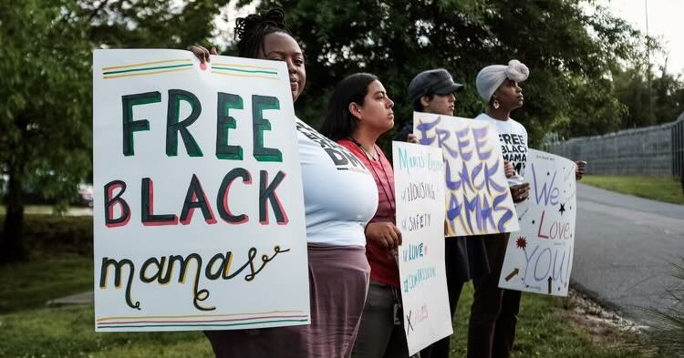 Women with protest signs reading Free Black mamas