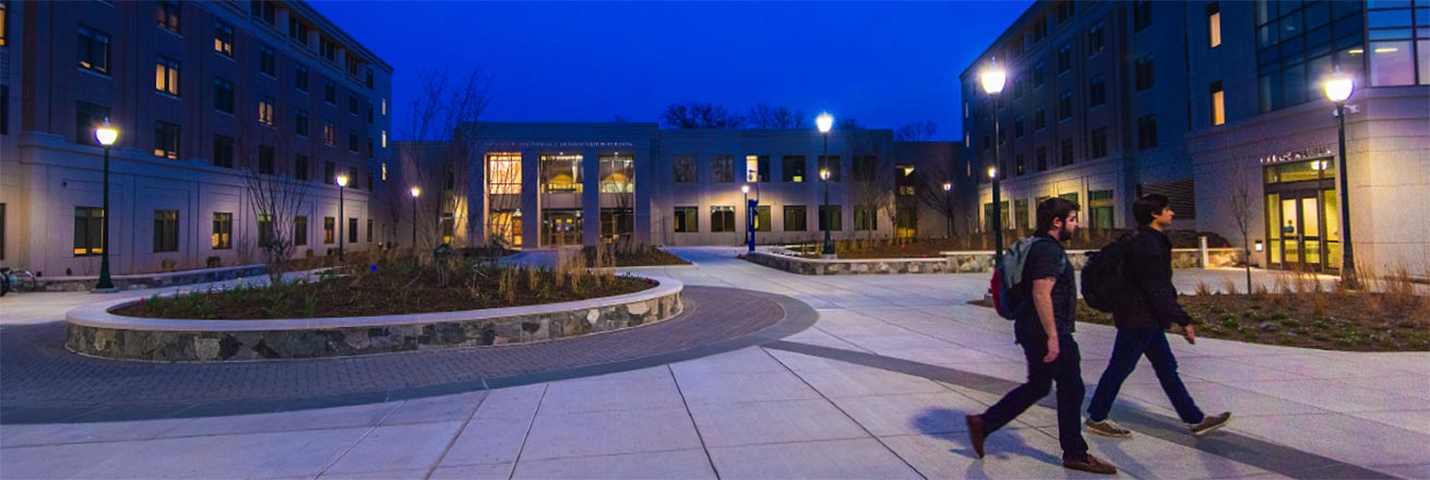 Students walking in front of the Don Myers building at night