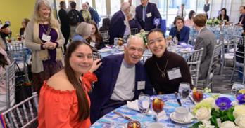 Students and donors smiling together at a table.