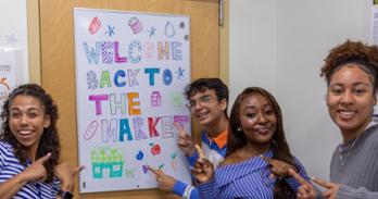 A group of students standing in front of The Market.