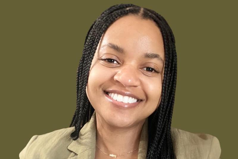 A young woman with braids smiling