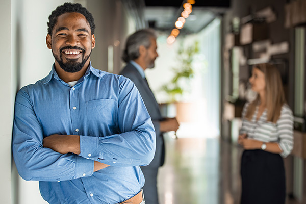 man leaning against a wall in office attire