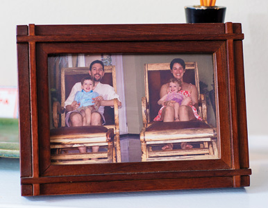 the Tomaseks and their children in two wooden chairs