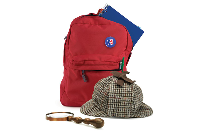 red backpack with a Sherlock Holmes hat and magnifying glass