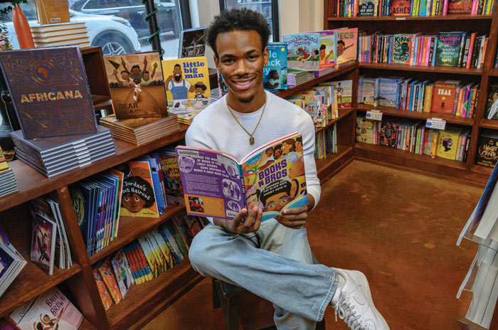 Sidney Keys III surrounded by children's books at Mahogany Books in Oxon Hill, Maryland