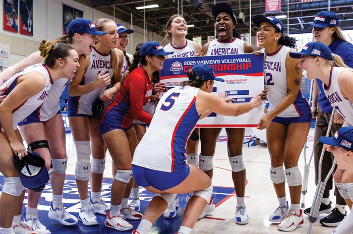 women's volleyball team celebrates in Bender Arena