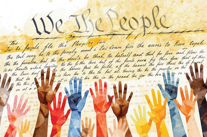 Hands raised before the Constitution, which says "We the People"