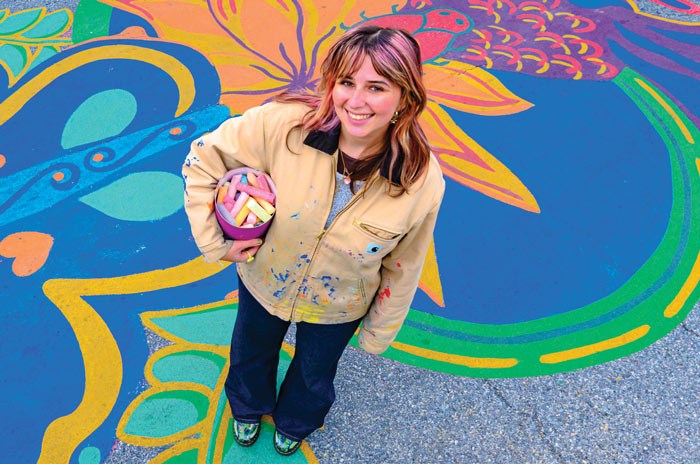 Samantha Hamilton stands before a colorful street mural