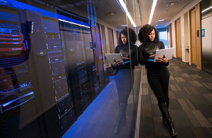 Woman with laptop near server racks Woman with laptop near server racks