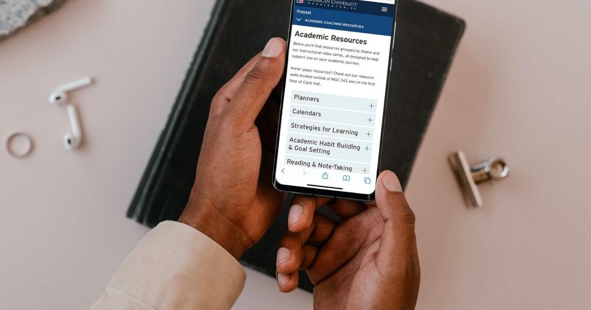Handheld cell phone displays an image of the Resource Library webpage.