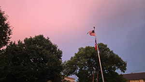 American flag blows in the wind on campus at sunset
