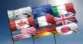 The flags of Canada, United States, Germany, France, the European Union, Italy, the United Kingdom, and Japan blow in the wind. Another flag says G7 2025 Kananskis.