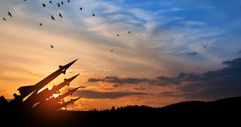 Missiles are outlined against the backdrop of a sunset sky