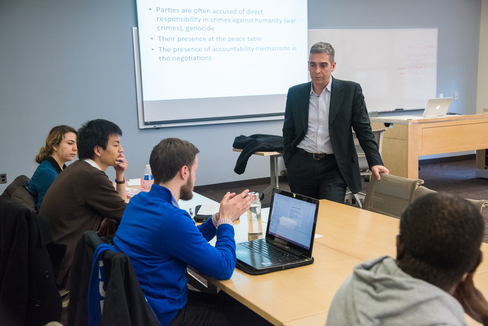 Professor Anthony Wanis-St. John speaks with students in a classroom. 