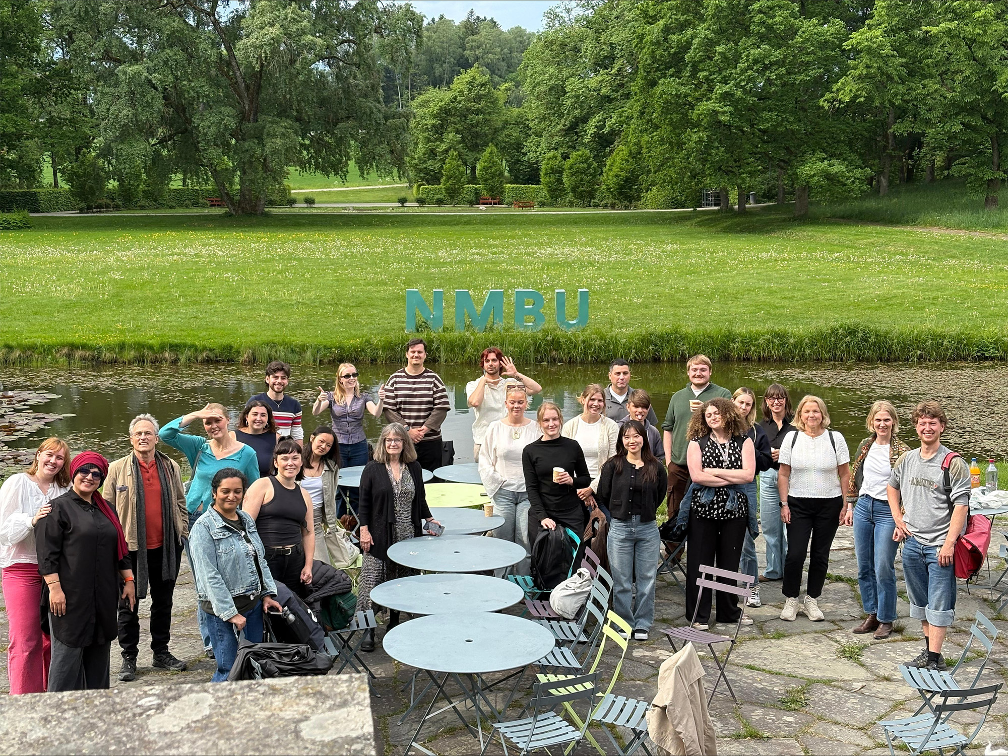 NMBU Practicum students group photo in front of grass and NMBU sign.