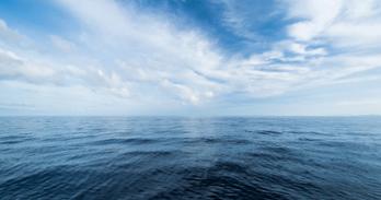 A clear blue sky over ocean waves