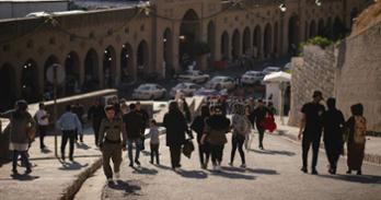 People walking around the Erbil Citadel in the Kurdistan Region of Iraq.