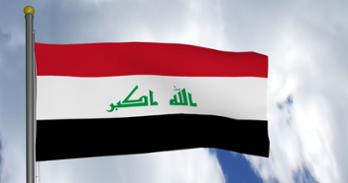 The flag of Iraq flying in the sky.