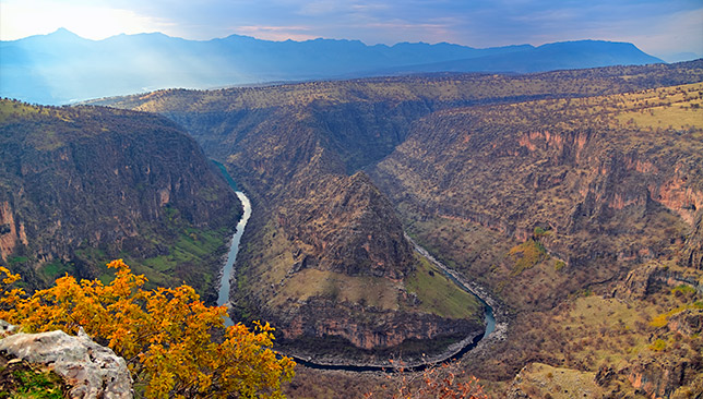 aerial view of water snaking through a Kurdish valley in a horseshoe shape