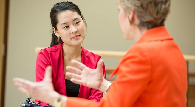 A student and professor having a discussion.