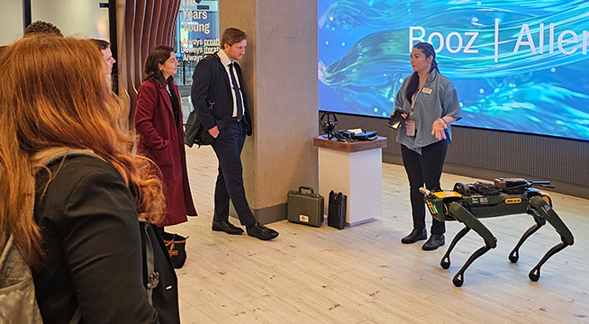 Students observe a robotic dog at Booz Allen Hamilton.