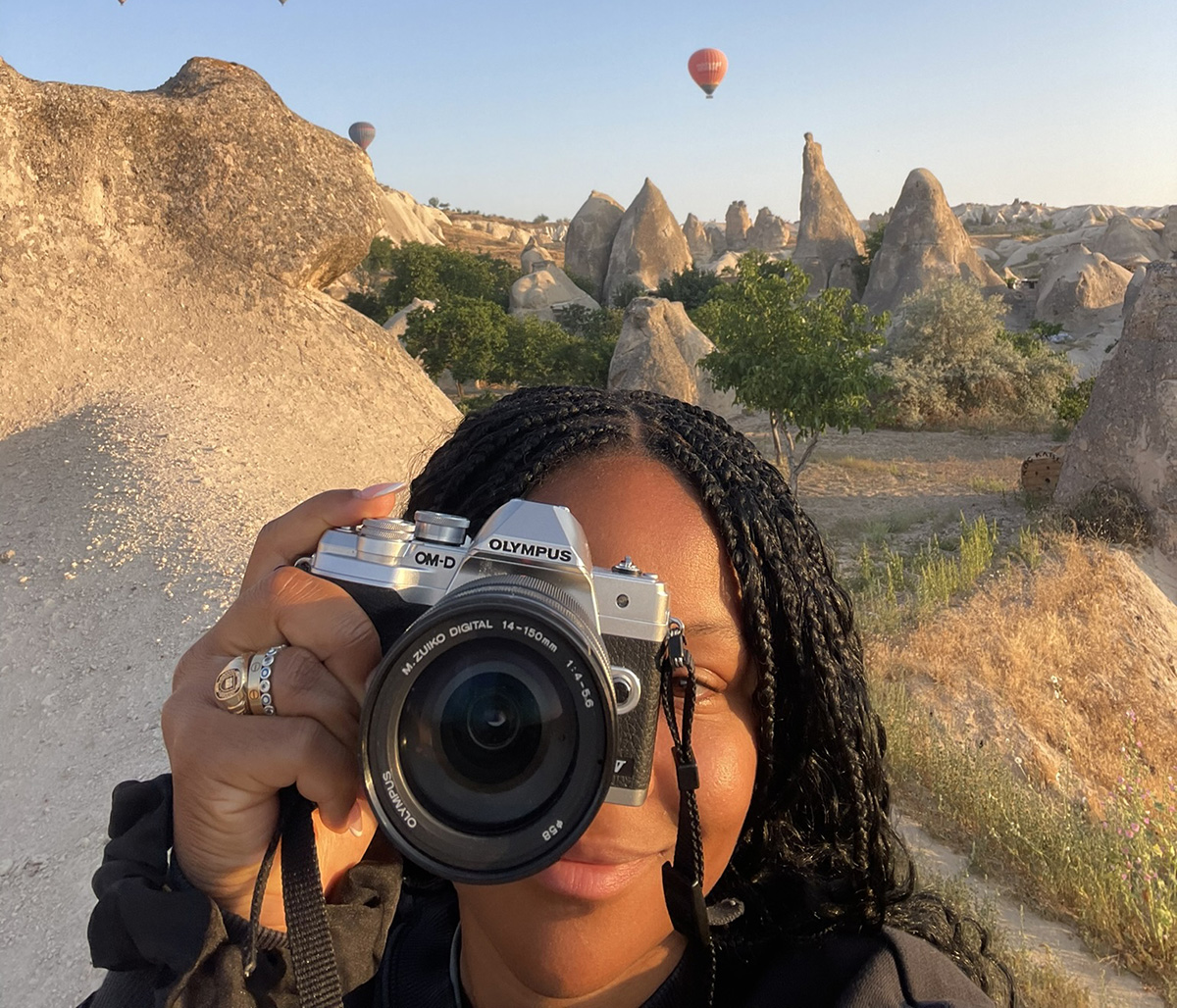An SIS student with a camera stands in front of the Fairy Chimneys in Turkey.