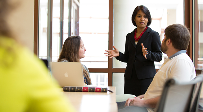 Students listen intently to a professor in a classroom.