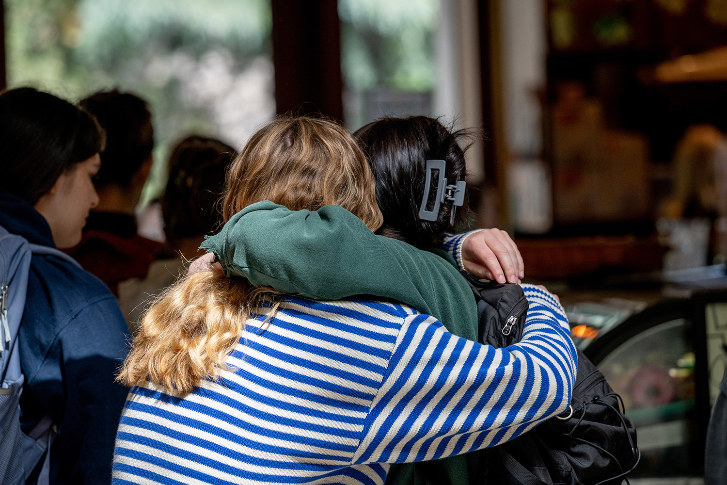 Two friends hug each other outside of the Davenport Lounge.