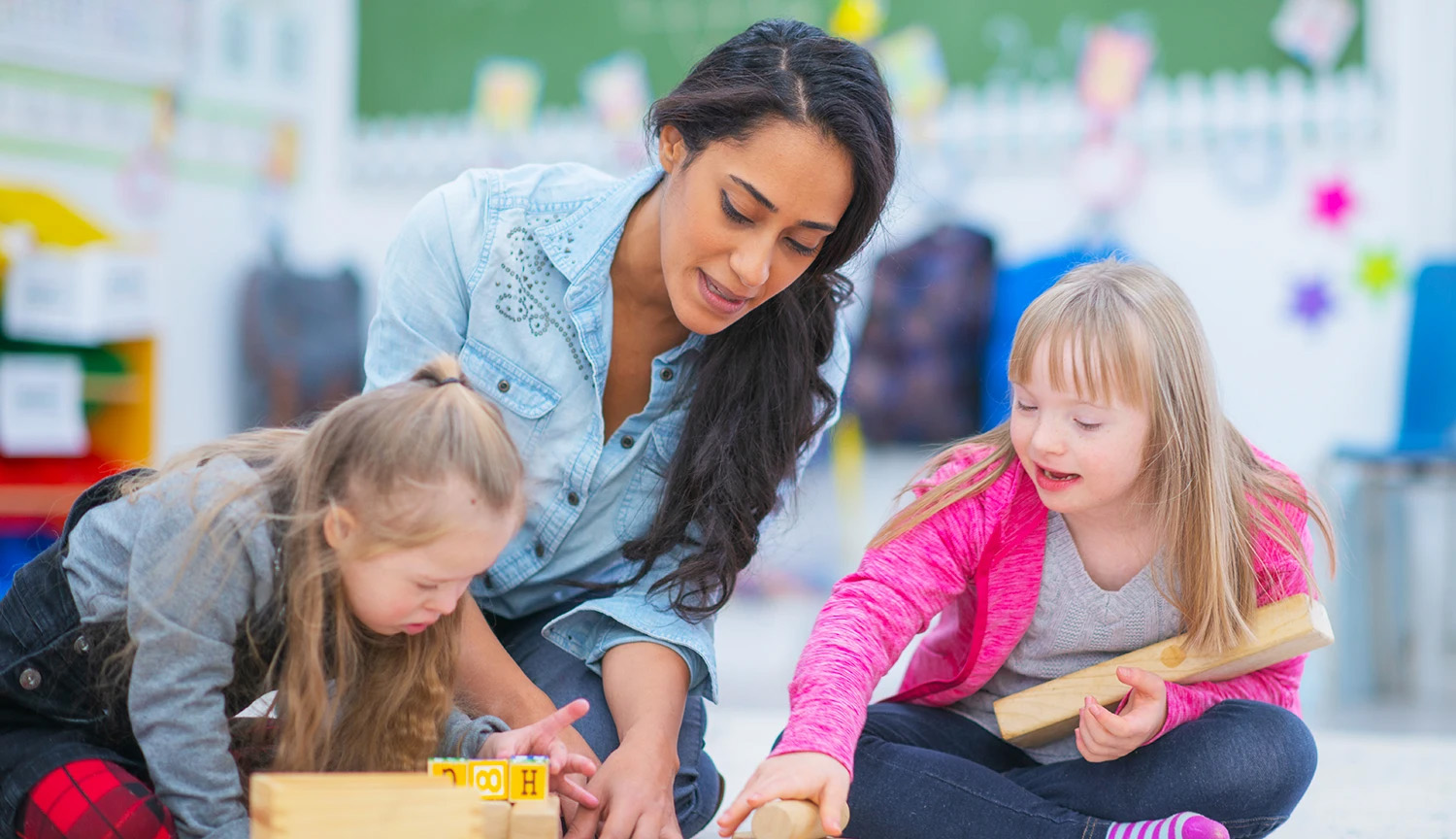 Woman teaching two children in preschool