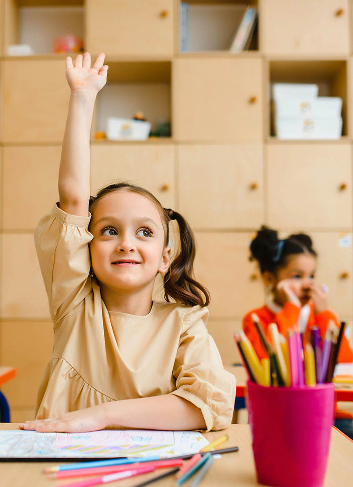 Young student with her hand raised.
