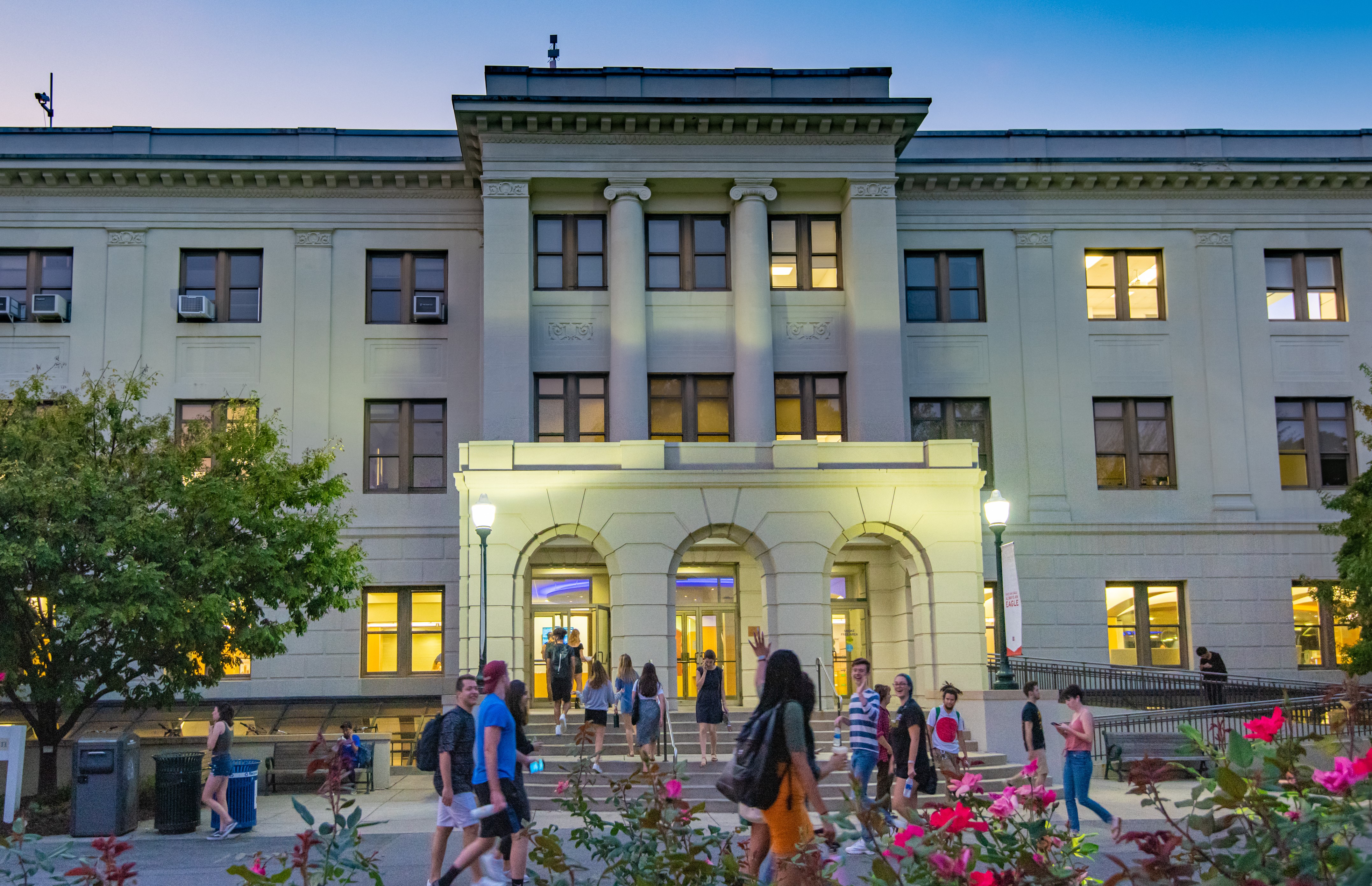 Exterior of Mary Graydon Center at dusk as student walk across the quad.