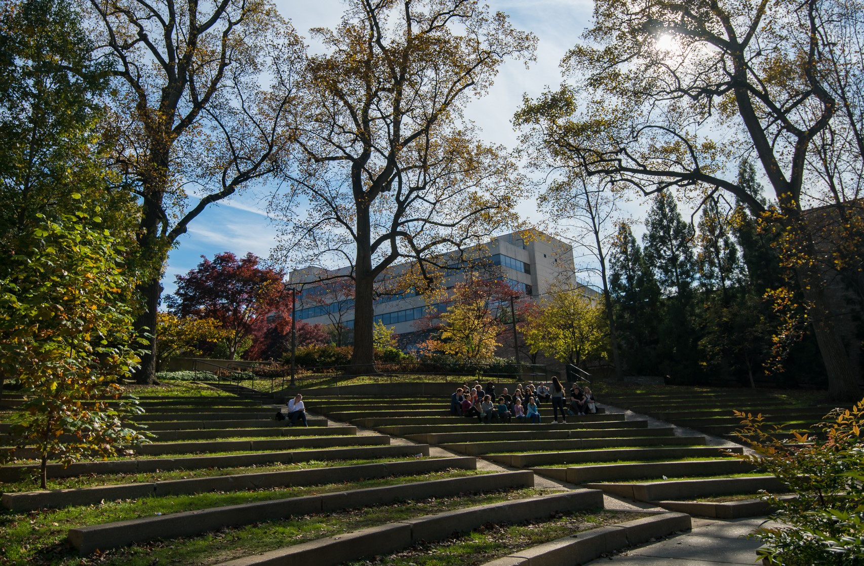 Outdoor amphitheater with students gathered on the steps for an event.