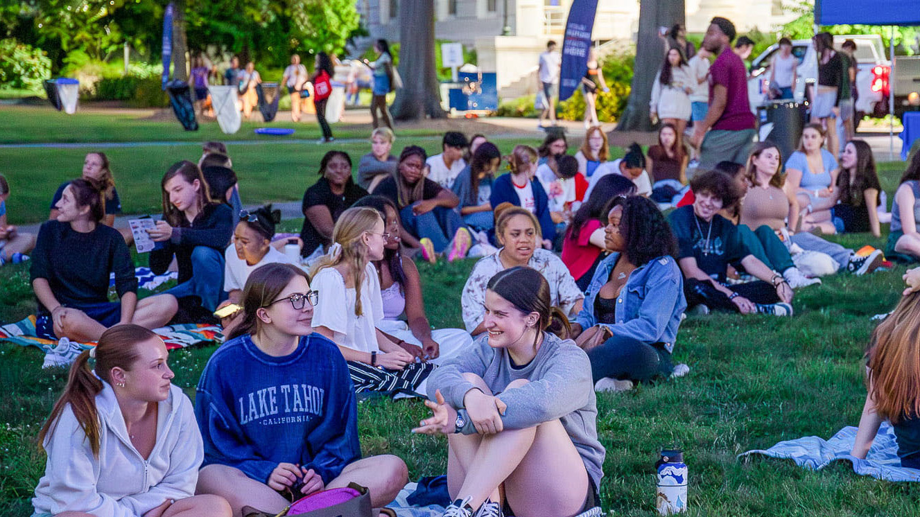 Students sit on picnic blankets on the Quad, chatting.