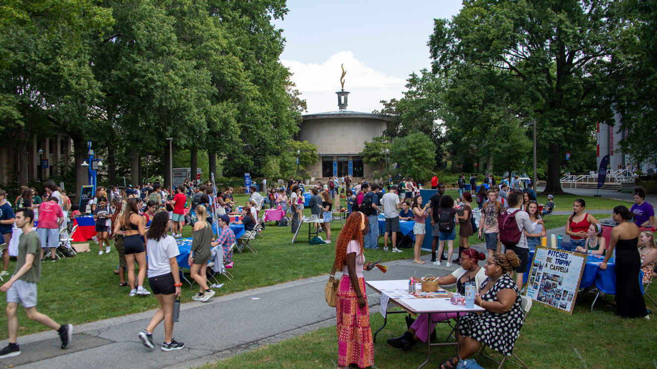 Students walk through tables set up on the Quad during the Student Involvement Fair. Kay Spiritual Life Center is visible in the background.